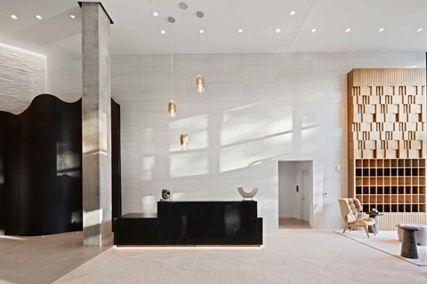 A reception area with a black reception desk and a wooden panelled wall.