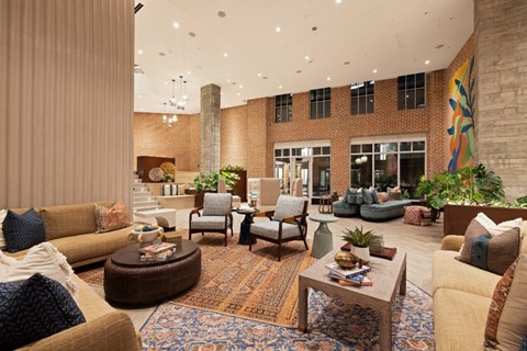 A living room with a large couch, a coffee table, and a rug.