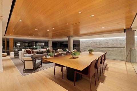 A modern dining room with a long wooden table and chairs.