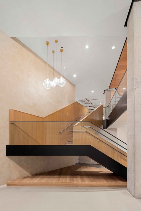 A modern staircase with a glass railing and wooden steps.