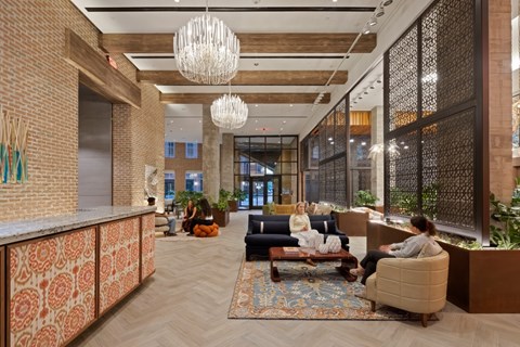 A modern office lobby with people sitting and chatting.