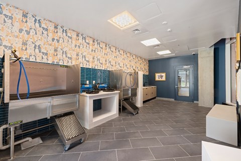 A kitchen with a blue tile backsplash and a stainless steel counter.