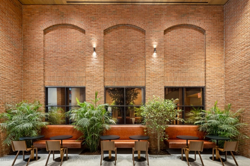 A room with a brick wall and a long table with chairs.