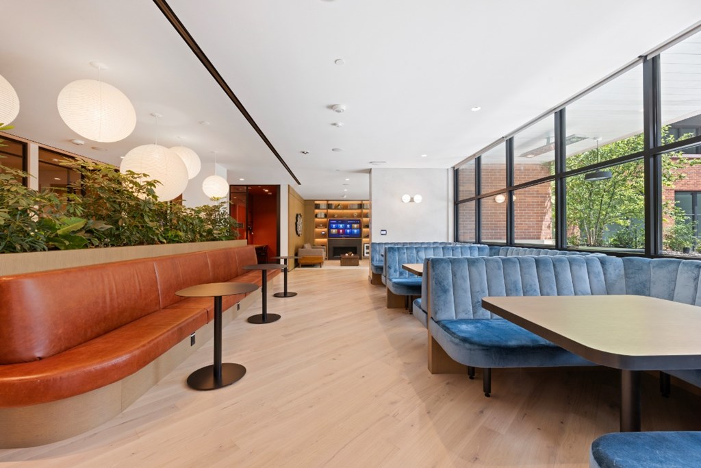 A long hallway with blue couches and tables.