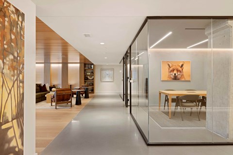 A modern living room with a glass wall and a painting of a fox.