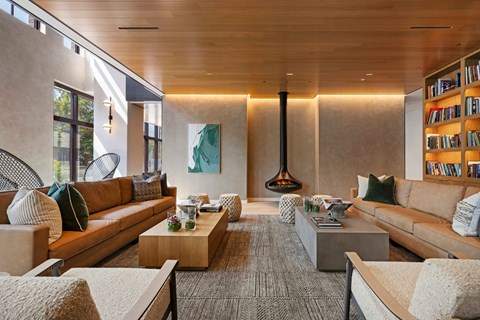 A modern living room with a large sectional sofa, a coffee table, and a fireplace.