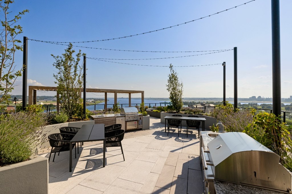A patio with a table and chairs overlooking a body of water.