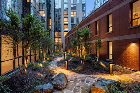 A pathway with rocks and trees in the middle of a city.
