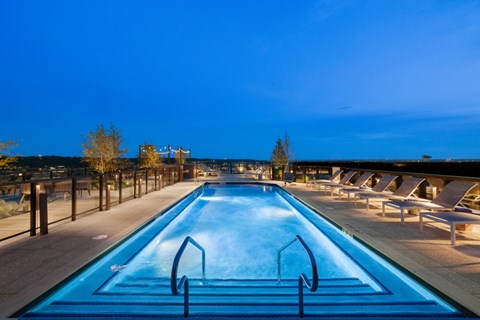 A large outdoor swimming pool with a blue tinted water.
