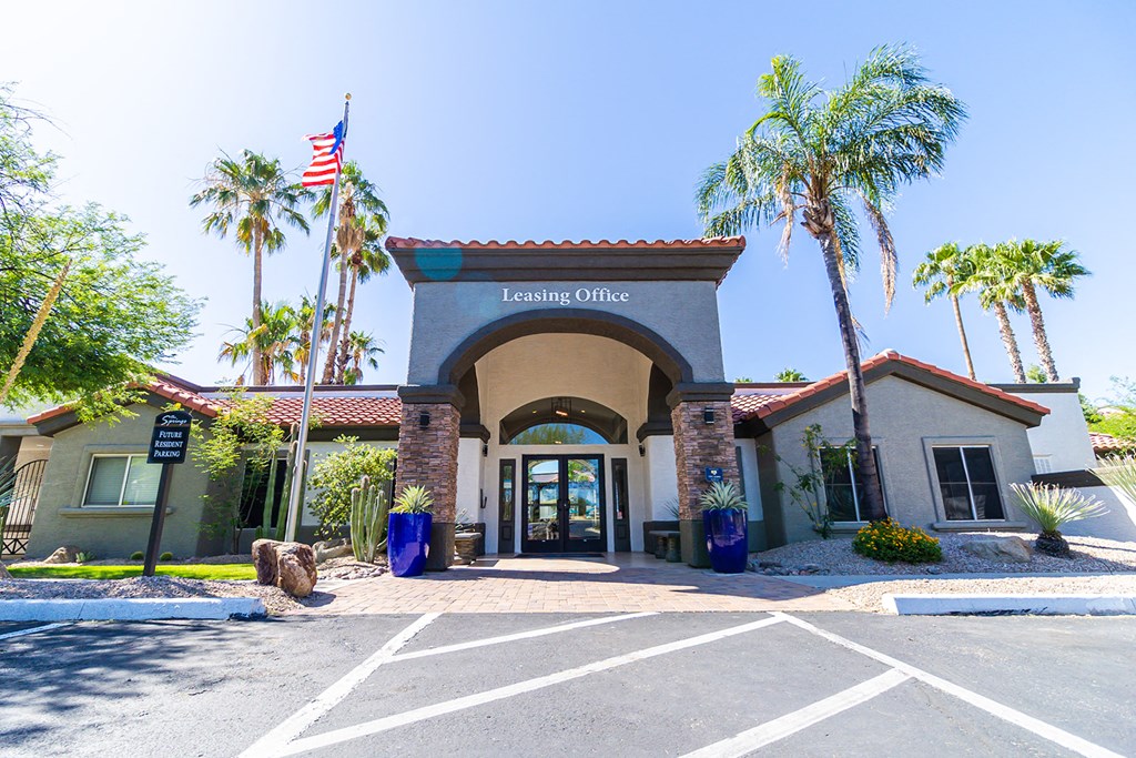 a building with an american flag and palm trees in front of it