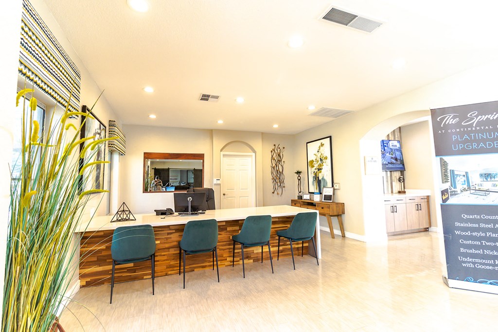 a room with a long table with blue chairs and a chalkboard on the wall