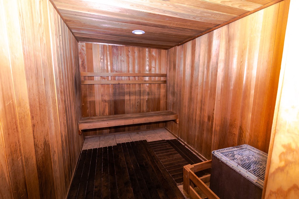 a wooden sauna with a bench and shelves