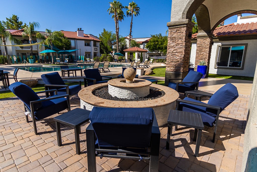 a patio with a fire pit and tables and chairs