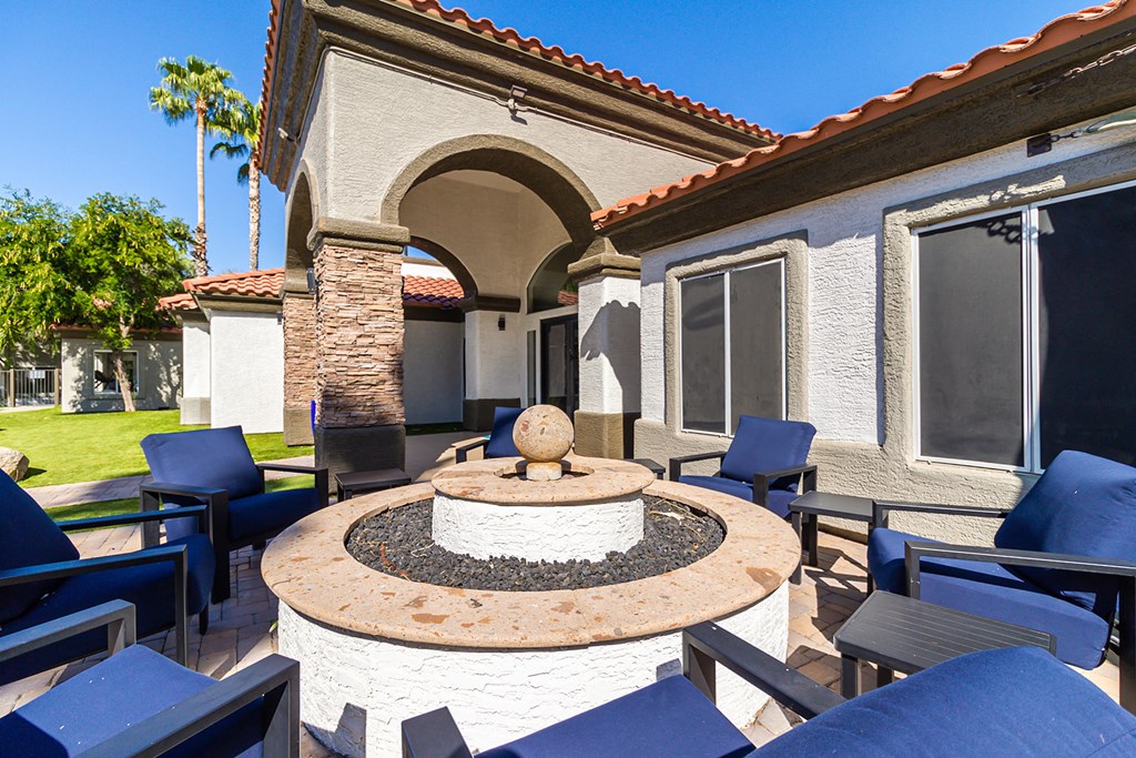 a patio with chairs and a fire pit