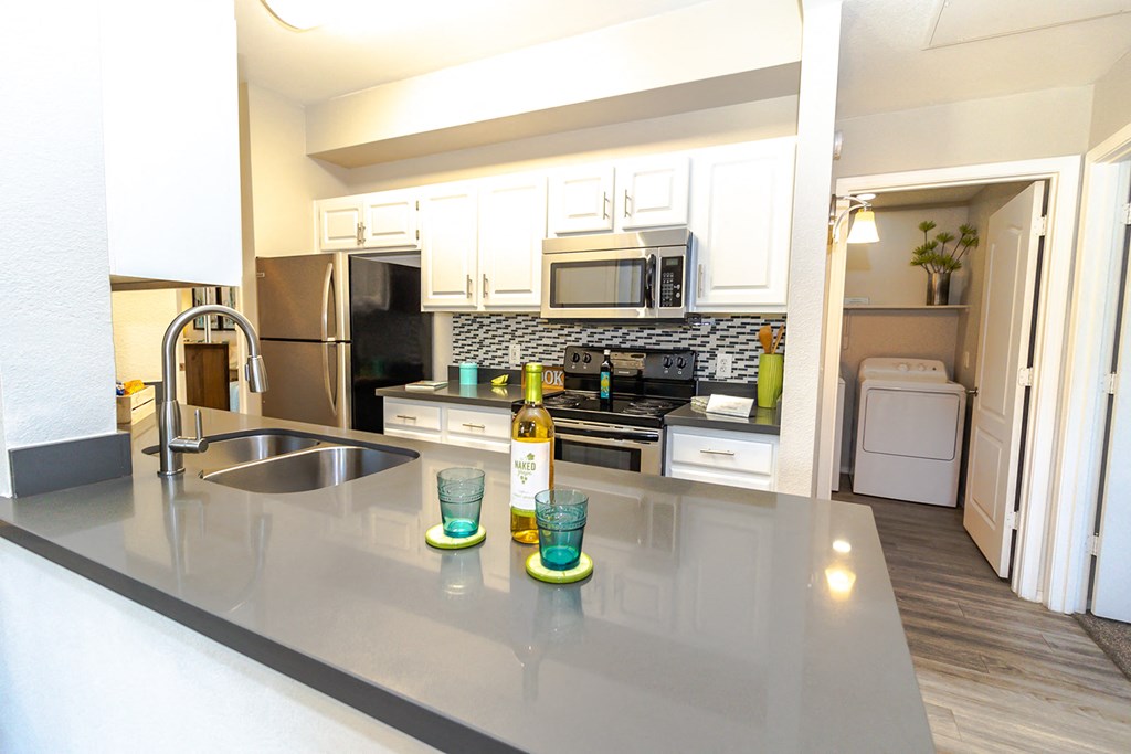 a kitchen with white cabinets and stainless steel appliances