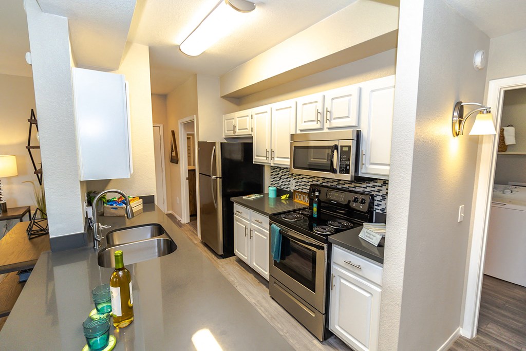 a kitchen with white cabinets and stainless steel appliances