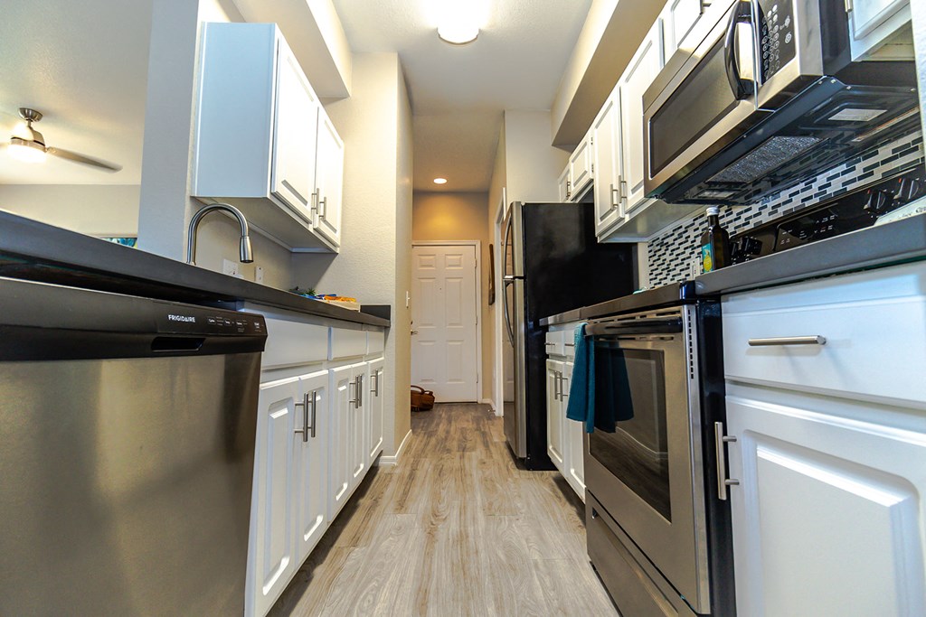 a kitchen with white cabinets and stainless steel appliances