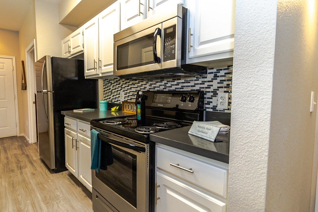 a kitchen with white cabinets and stainless steel appliances