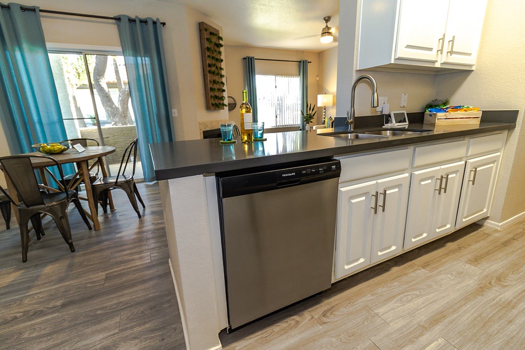 a kitchen with white cabinets and a stainless steel dishwasher