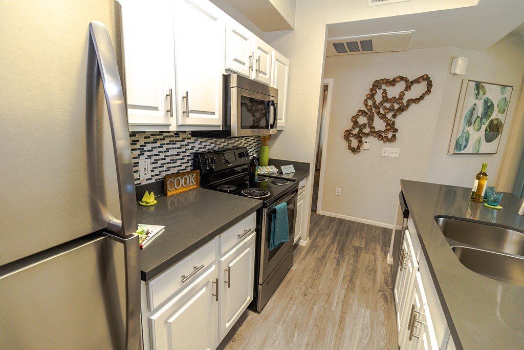 a kitchen with white cabinets and stainless steel appliances
