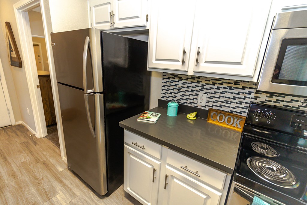 a kitchen with white cabinets and black appliances