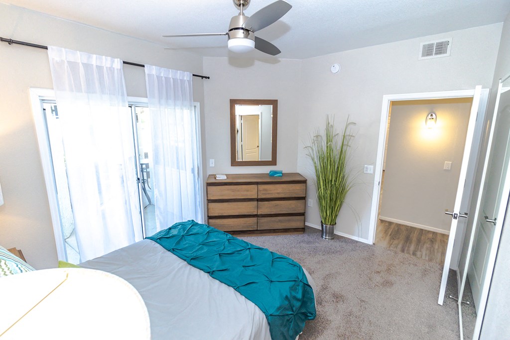 a bedroom with a bed and a ceiling fan