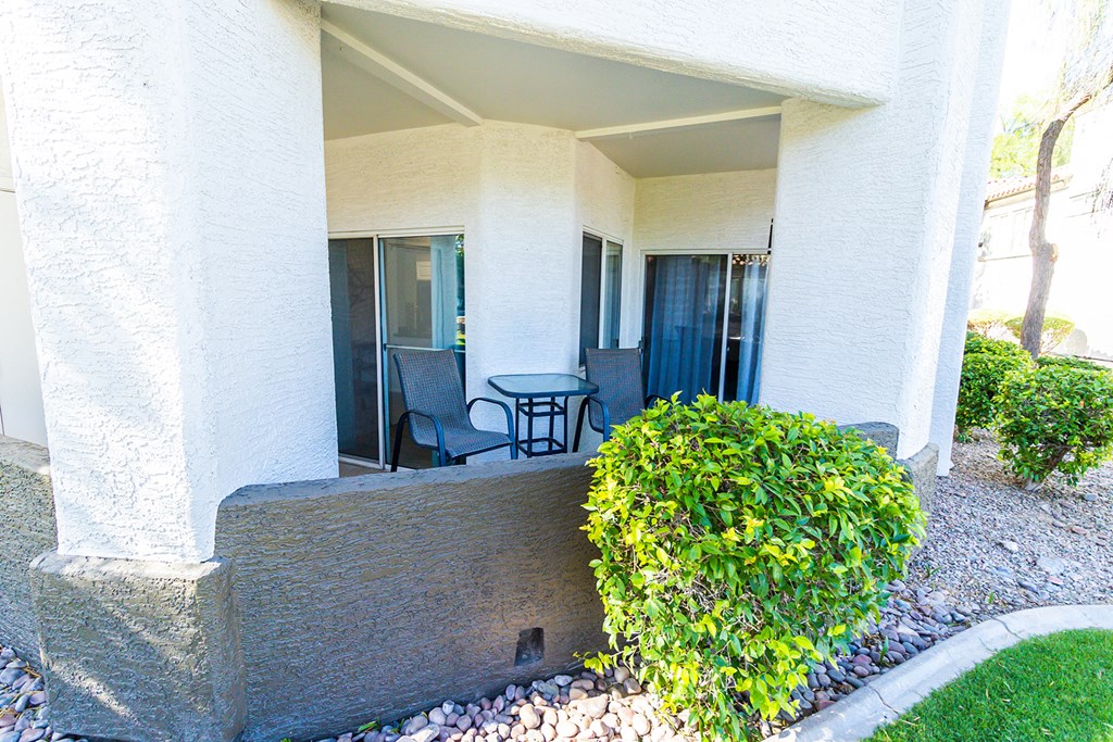 a balcony with two chairs and a table