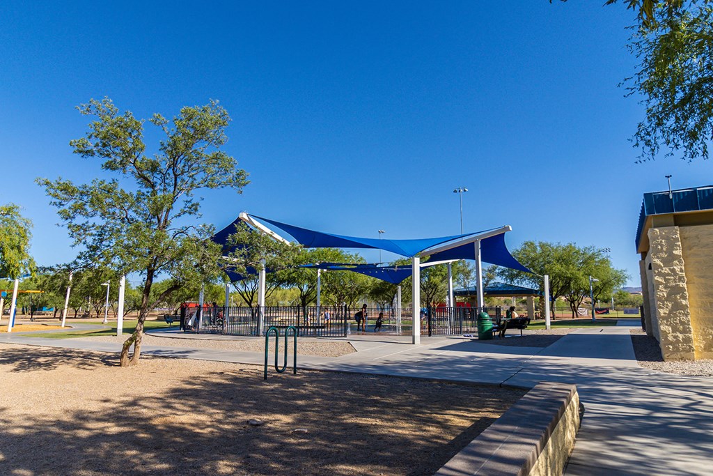 a park with a blue and white canopy over a playground
