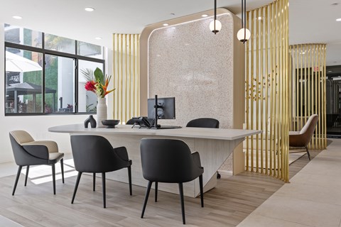 A modern office with a white desk and black chairs.