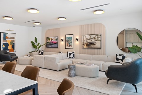 A modern living room with a white sofa set and a large mirror.