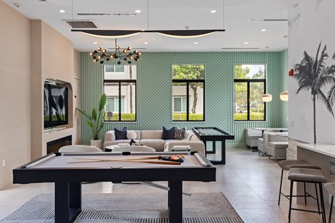 A modern living room with a pool table in the center.