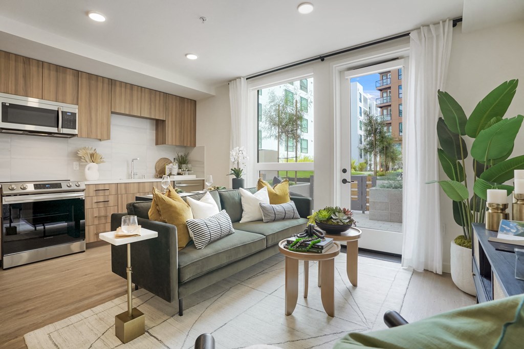 a living room with a couch and a kitchen with a window