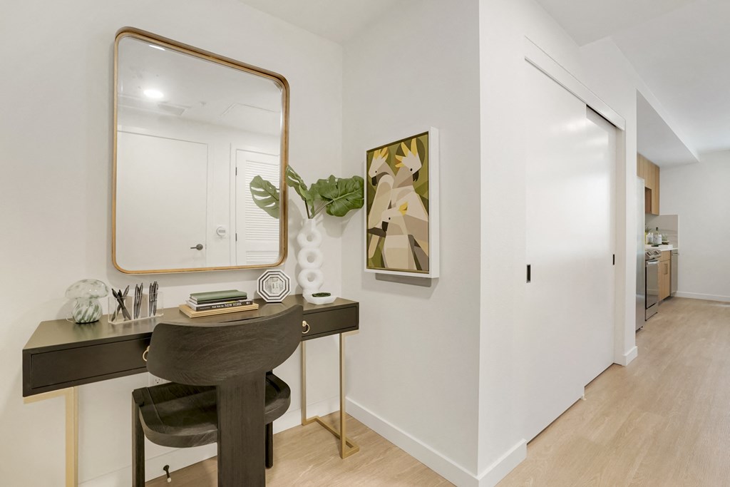 a bedroom with a vanity with a mirror and a door to a bathroom