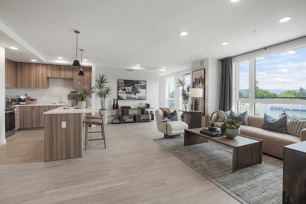 an open living room and kitchen with a view of a lake