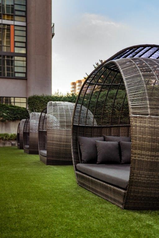 a couch sitting under an outdoor covering in a garden