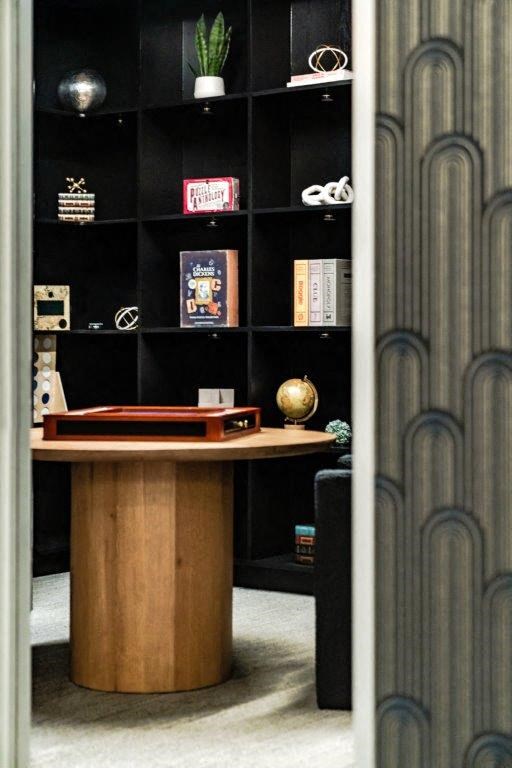 a room with a desk and a book shelf