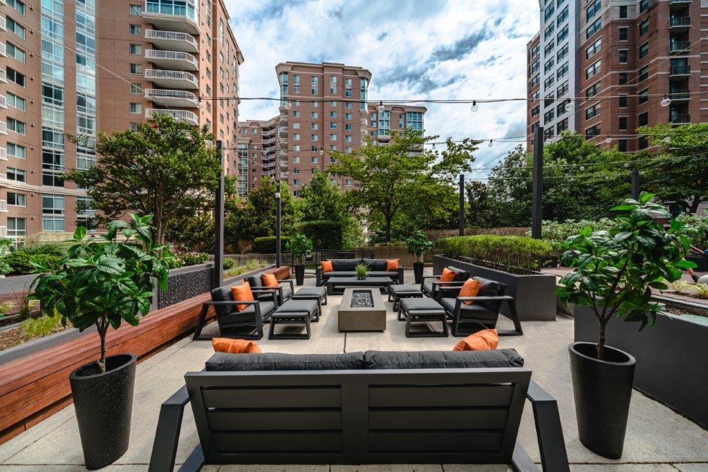 a lounge area on the roof of a building with benches and tables