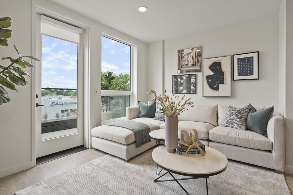 a living room with a couch and a table     and a balcony