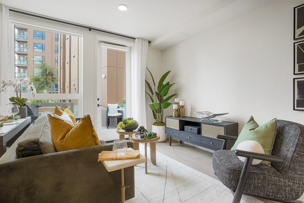 a living room with a couch and a chair and a large window