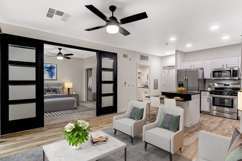 A modern kitchen with a breakfast bar and a living room area with a sofa and chairs.