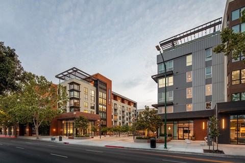 A modern apartment complex with a mix of grey and brown buildings.