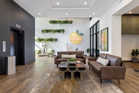 a living room with couches and a coffee table in front of a apple wall