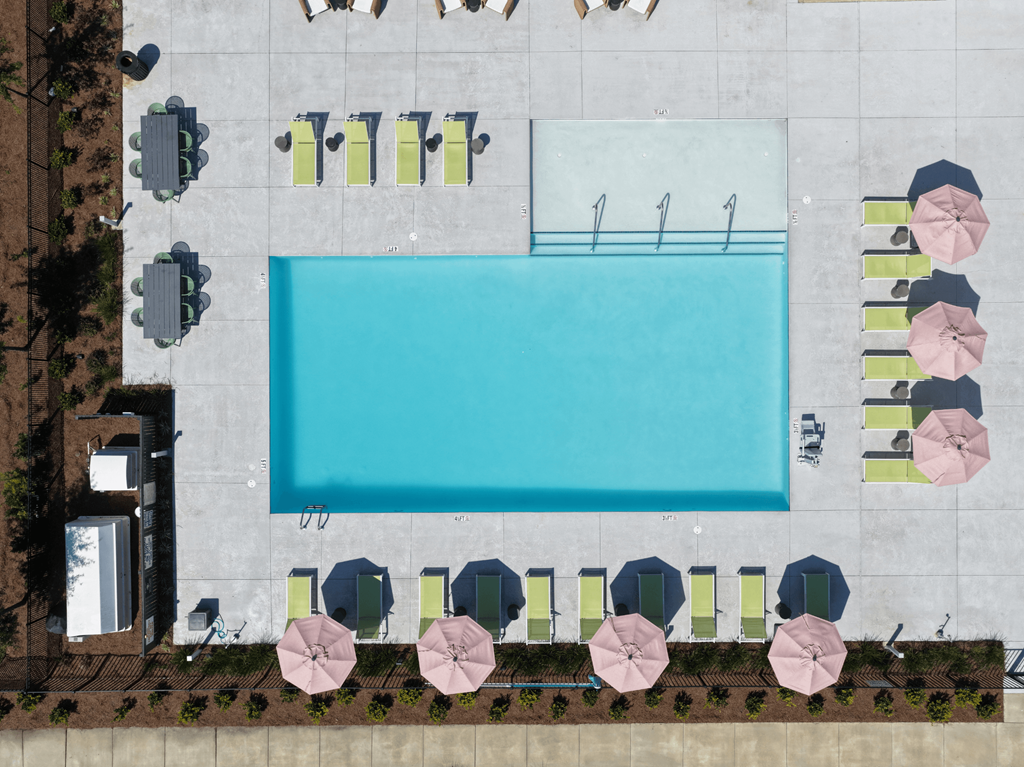 A large rectangular pool surrounded by chairs and umbrellas.