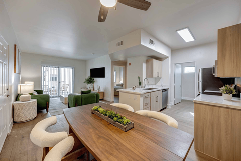 A modern kitchen with a wooden table and chairs.