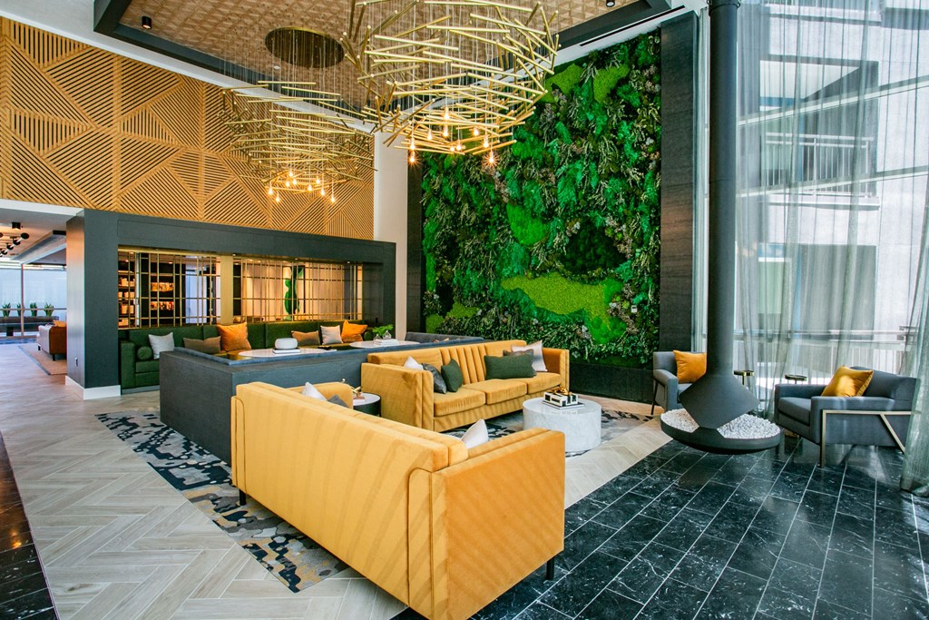 Clubhouse lounge sitting area green accent wall yellow couches light fixture.