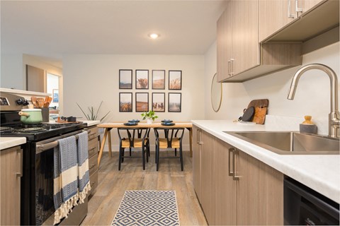 A kitchen with a table and chairs in the middle.