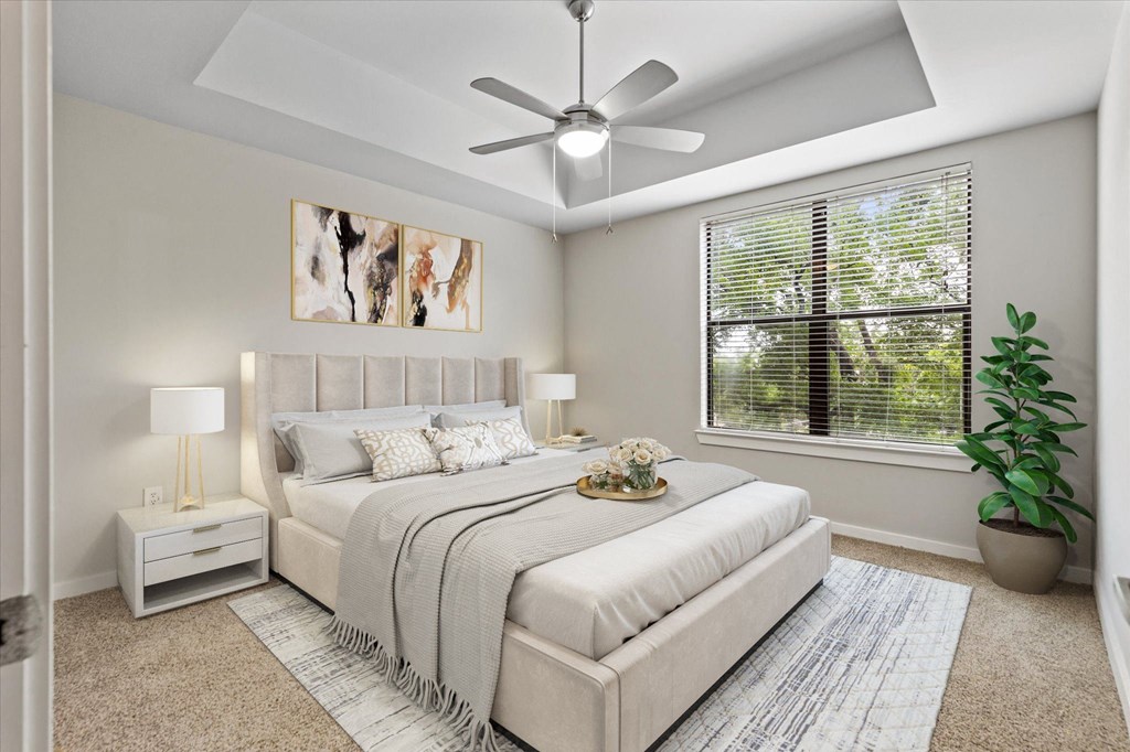 a bedroom with a large window and a ceiling fan