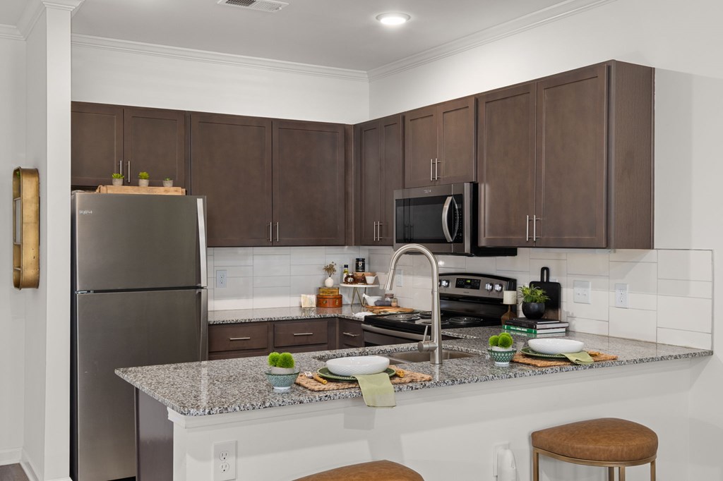 A kitchen with brown cabinets and a granite countertop.