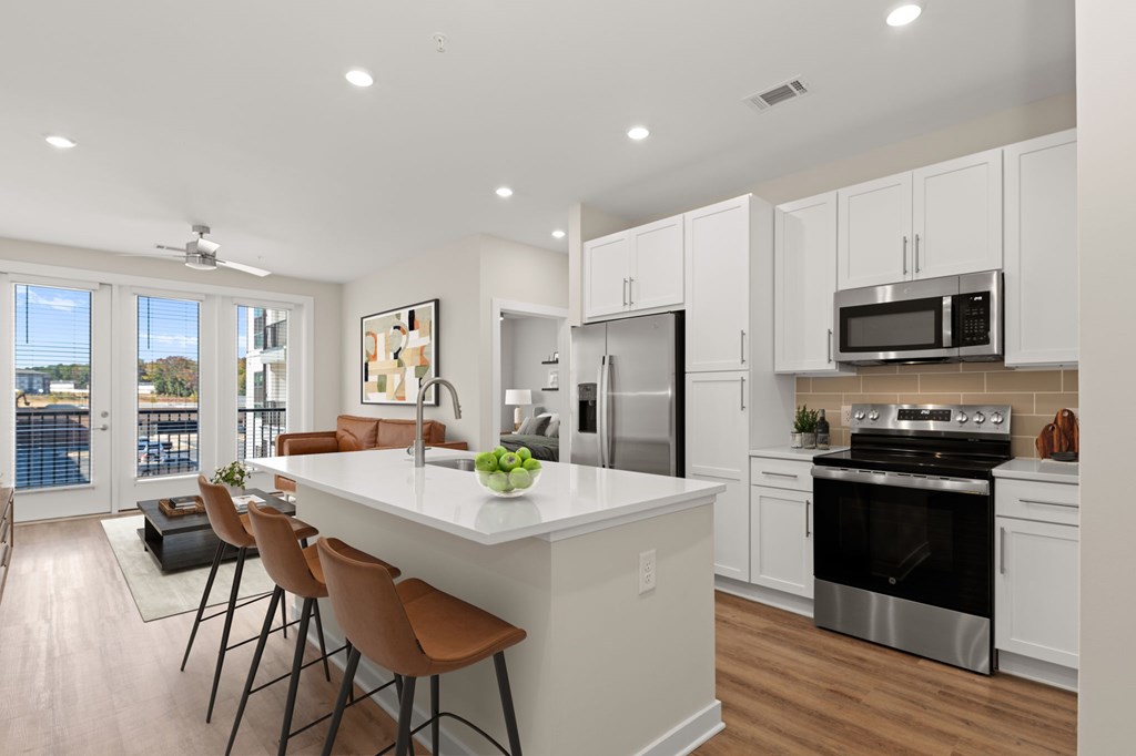A modern kitchen with white cabinets and a large island.