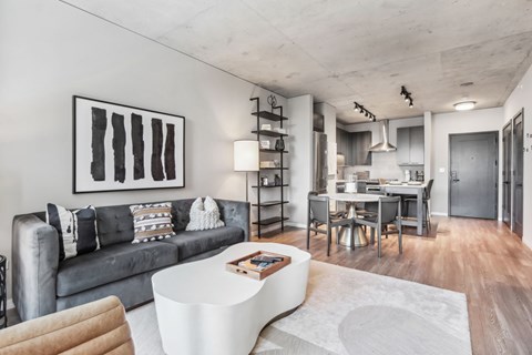 A modern living room with a grey couch and a white coffee table.